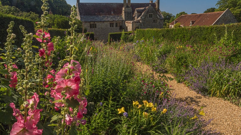 Double colourful flower borders looking down to Manor House